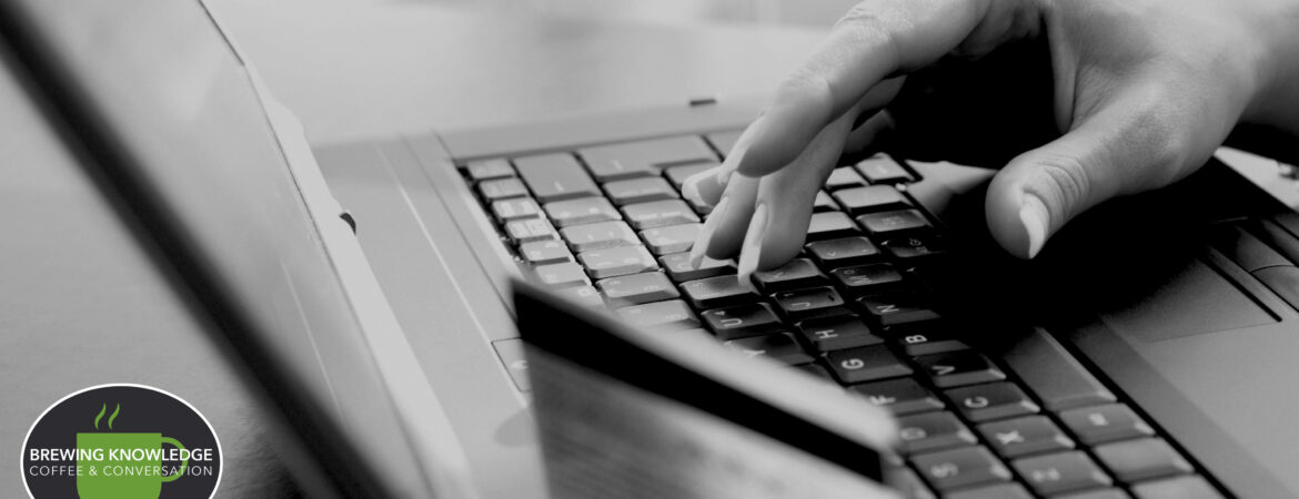 Person using laptop and holding a credit card